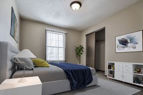 Grand Forks apartment for rent - Grand Forks Primrose Apartments. A bedroom with a bed and a dresser in front of a window