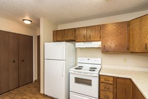 Grand Forks apartment for rent - Grand Forks Ridgemont Apartments. A kitchen with white appliances and a closet in the background.