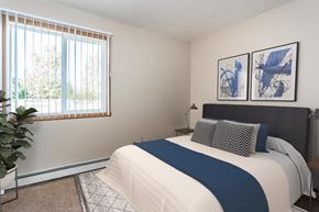 Crookston apartment for rent - Grand Forks, ND Riverwood Apartments. A bedroom with a large bed and a window