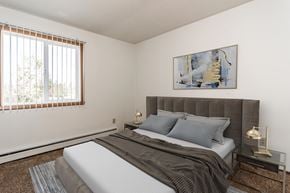 Crookston apartment for rent - Grand Forks, ND Riverwood Apartments. A bedroom with a bed and a large window