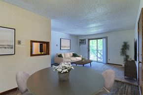 Grand Forks apartment for rent - Grand Forks, ND Roughrider Apartments. a dining area with a table and chairs and a couch in the background