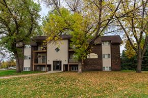 Grand Forks apartment for rent - Grand Forks, ND Roughrider Apartments. The exterior of  a three level apartment building with a sidewalk leading to the front door.