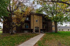Grand Forks apartment for rent - Grand Forks, ND Roughrider Apartments. The exterior of  a three level apartment building with a sidewalk leading to the front door.