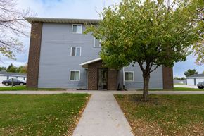 Grand Forks apartment for rent - Grand Forks, ND Southview III Apartments. The front of a blue building with a sidewalk and a tree