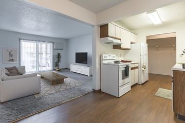 Grand Forks apartment for rent - an open living room and kitchen with white appliances and a tv