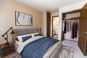 Grand Forks apartment for rent - a bedroom with a bed and a closet with clothes in it