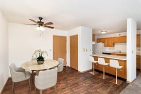 Hutchinson apartment for rent - a dining room with a table and chairs and a kitchen. Hutchinson, MN Deer Park Apartments