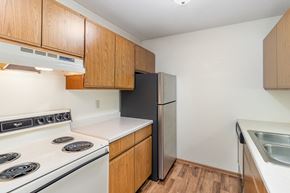 Hutchinson townhouse for rent - a kitchen with white appliances and wooden cabinets and a refrigerator. Hutchinson, MN Twin Oaks