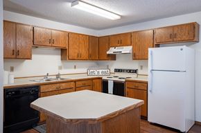 Fargo apartment for rent - a kitchen with white and black appliance. Fargo, ND Kentwood Manor Apartments
