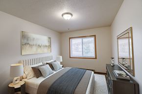 Moorhead apartment for rent - a bedroom with a bed and a dresser and a window. Moorhead, MN South Park Apartments