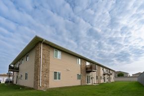 Moorhead apartment for rent - an apartment building with a cloudy sky in the background. Moorhead, MN Woodstone Apartments