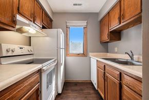 Omaha apartment for rent - Omaha, NE Woodland Pines Apartments. A kitchen with white appliances and wooden cabinets