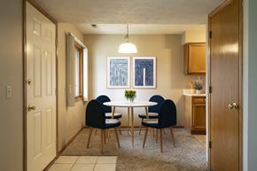 Omaha apartment for rent - a dining room with a white table and blue chairs  at Woodland Pines, Omaha