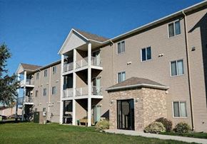 West Fargo apartment for rent - A large apartment building with a grassy area in front of it. Fargo, ND Eagle Run Apartments.