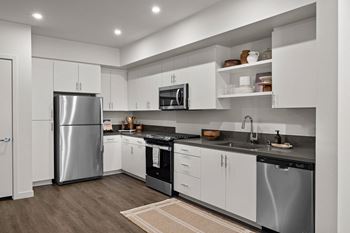 A kitchen with white cabinets and stainless steel appliances