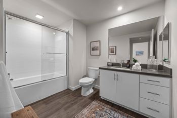 A bathroom with a shower toilet and sink and a mirror
