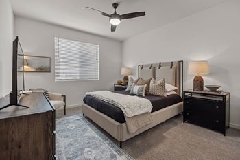 A bedroom with a bed and a ceiling fan