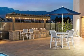 A patio with a bar and tables with chairs and umbrellas