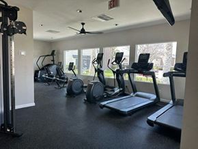 Corona apartment for rent - a gym with cardio equipment and windows in a building at Lincoln Park Apartments, Corona California