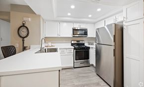 Upland apartment for rent - A modern kitchen with a white countertop and stainless steel appliances. at The Oaks Apartments, California, 91786