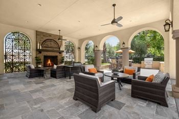 Covered outdoor patio with fireplace and lounge seating