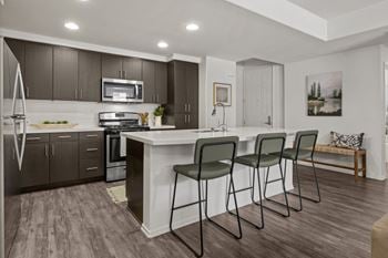 Open concept kitchen with white island and bar stools