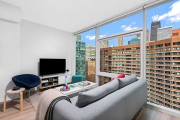 Chicago apartment for rent - a living room with a couch and a tv and a view of the city