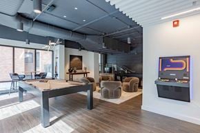 Chicago apartment for rent - A room with a pool table and a TV on the wall.