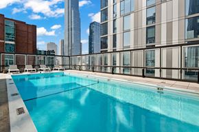 Chicago apartment for rent - A large swimming pool on a rooftop with a city skyline in the background.