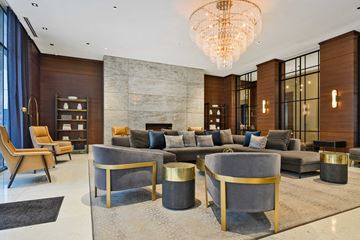 Chicago apartment for rent - A modern living room with a grey sofa and a gold chandelier.
