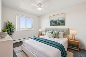 Denver apartment for rent - A bedroom with a large bed and a painting on the wall.