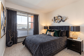 Denver apartment for rent - A bedroom with a large bed and a window with curtains.
