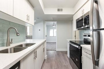Scottsdale apartment for rent - a kitchen with white cabinets and a sink and a refrigerator