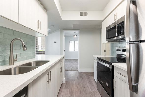 Scottsdale apartment for rent - a kitchen with white cabinets and a sink and a refrigerator