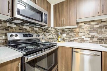 Phoenix apartment for rent - A kitchen with a stove top oven and microwave above it.