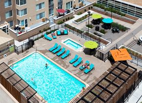 Denver townhouse for rent - an overhead view of a swimming pool with chairs and umbrellas
