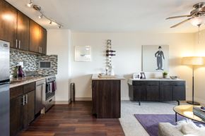 Denver apartment for rent - A modern kitchen with dark wood floors and a marble backsplash.