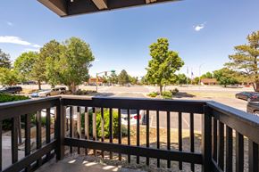 Aurora apartment for rent - the view from the deck of a building overlooking a parking lot