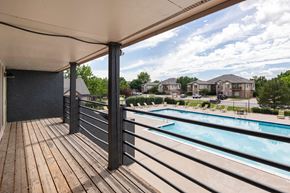 Aurora apartment for rent - the view of a swimming pool from a balcony with wooden decking