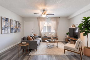 Phoenix apartment for rent - A living room with a grey couch, a wooden coffee table, a television, and a plant.