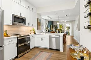 Wilton Manors townhouse for rent - A kitchen with white cabinets and appliances.