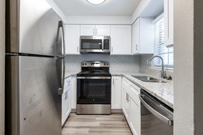 Tampa apartment for rent - A modern kitchen with a stainless steel refrigerator and white cabinets.
