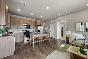 Golden apartment for rent - A modern kitchen with wooden cabinets and a dining table.
