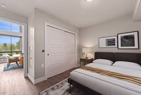 Golden apartment for rent - A bedroom with a large bed and a sliding door leading to a balcony.
