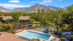 Salt Lake City apartment for rent - an aerial view of a swimming pool with mountains in the background