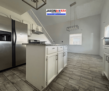 El Paso apartment for rent - A kitchen with a refrigerator, cabinets, and a stove top oven.