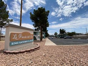 El Paso apartment for rent - A sign for La Puerta del Sol is in front of a parking lot.
