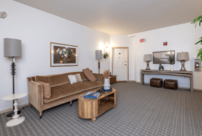 Fargo apartment for rent - A living room with a brown couch, a coffee table, and a lamp at Eighth Street Manor Apartments, North Dakota, 58103