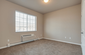 Moorhead apartment for rent - A room with a window and a wall-mounted air conditioner.