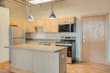 Moorhead apartment for rent - A kitchen with wooden cabinets and a stainless steel refrigerator, Kassenborg Apartments, Moorhead, MN